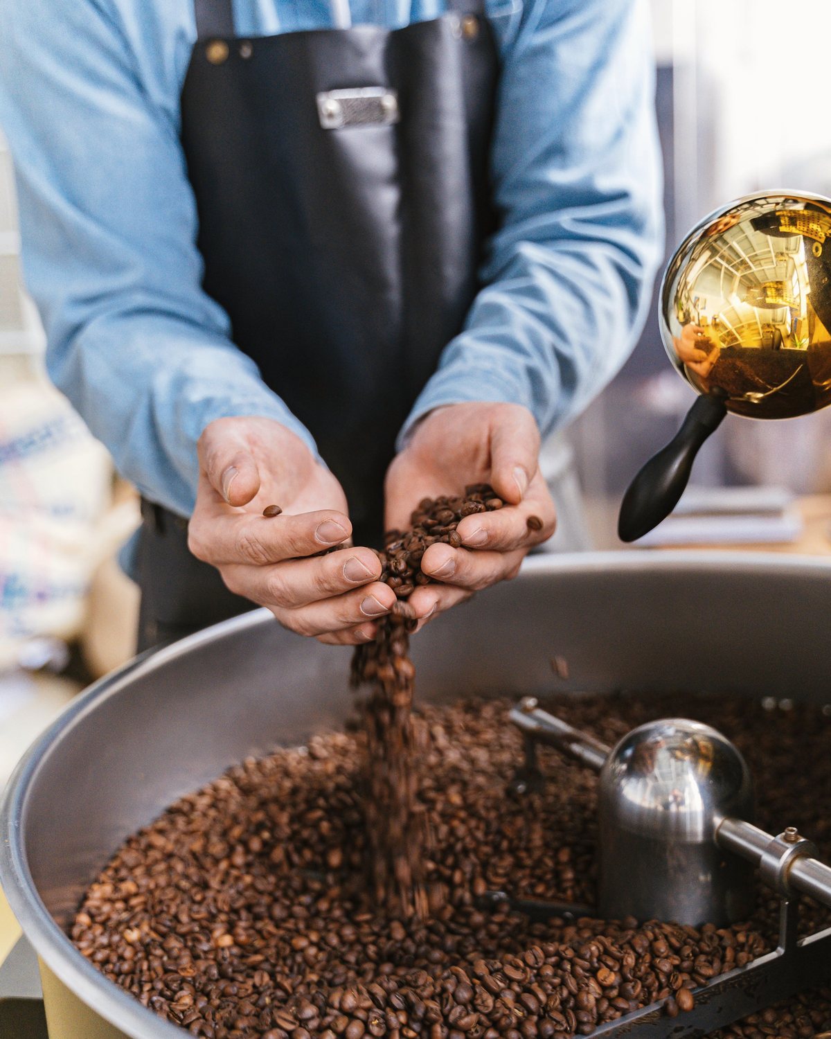 يدان تقلّبان البن المحمّص في صينية التبريد